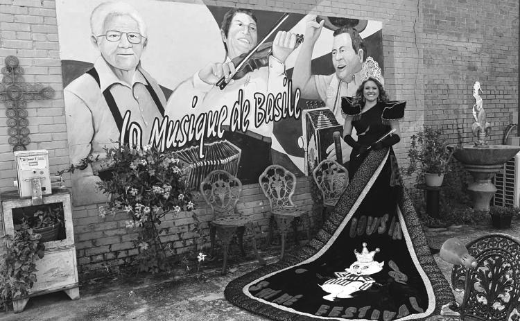 Abigail Fruge, the reigning La. Swine Festival Queen, poses in her full regalia at the Music of Basile mural in old downtown.