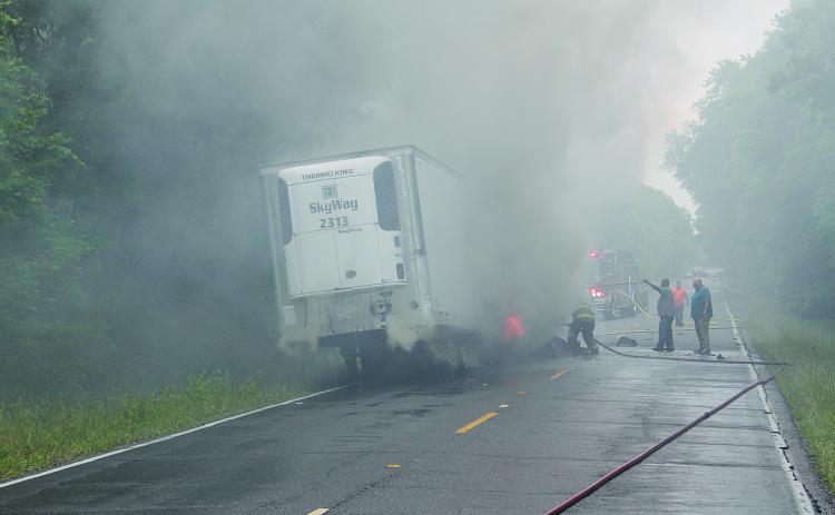 Pictured are firefighters as they battle to contain a truck fire on the Whiteville Road on Tuesday, May 3. What caused the refrigerated trailer to be engulfed in flames was not known as of press time.  (Gazette photo by Tony Marks)