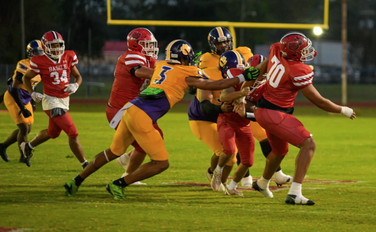 Cameron Seriale (3) and other members of the Ville Platte defense combine for a stop against the Basile Bearcats last Friday night as the Bulldogs earned their second win of the season. (Photo by Tonya Ortego)
