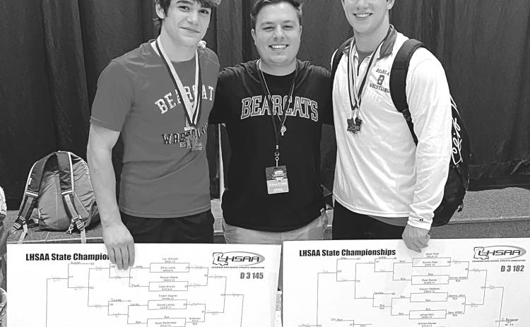 Bearcat wrestling coach Ben Bertrand congratulates seniors Luc Johnson (left) and Christian Bergeron (right) on their individual state championships in their respective weight classes. Both claimed titles for the second consecutive year. (Photo by Tracy Veillon)