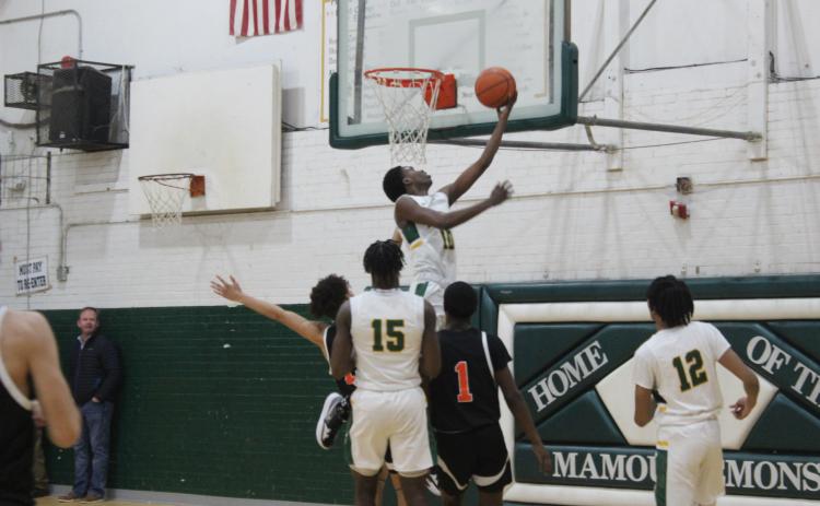Tyrion Broussard (10) elevates himself over a pair of Pine Prairie defenders. Gazette photo by Rhett Manuel