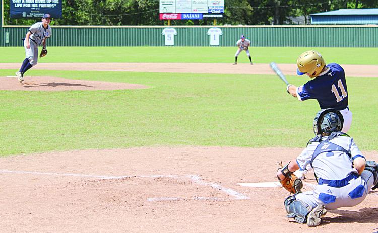 Sacred Heart leadoff hitter and starting shortstop Gabe Wilmouth (11) finishes his swing in the Trojans’ deciding game against Ascension Christian on Saturday, April 30.  (Gazette photo by Rhett Manuel)